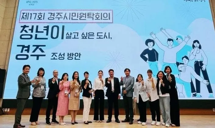 제17회 경주시민원탁회의 무대 앞에서 운영진과 퍼실리테이터가 행사 배경 화면을 뒤로 하고 서 있는 모습